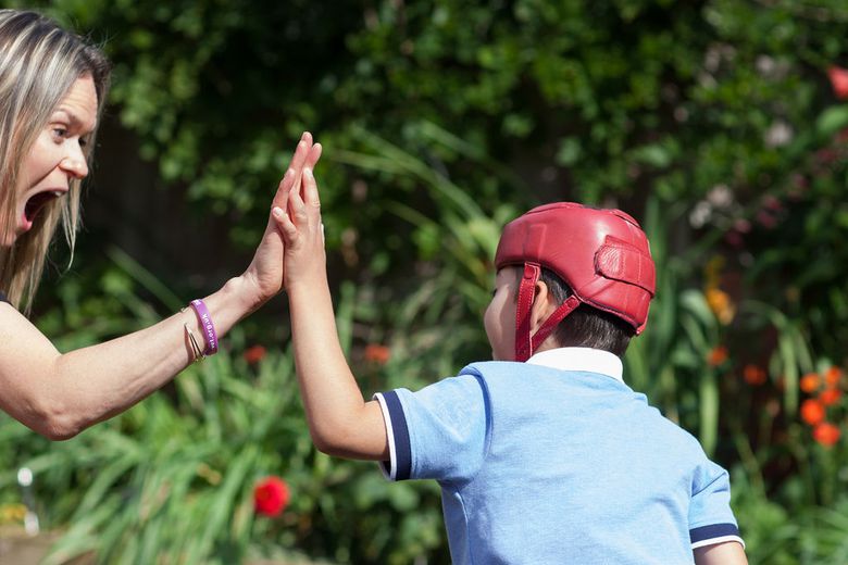 Jacob's story - Jacob high fives mum Jenny